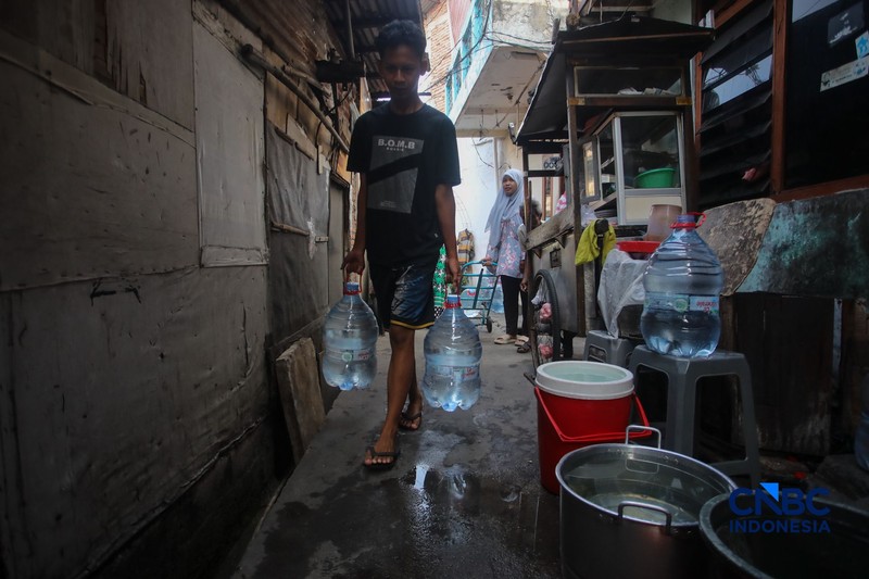 Warga mengambil air bersih dari mobil layanan bantuan air bersih di Jalan H Mawar, Sunter Jaya, Tanjung Priok, Jakarta Utara, Senin (6/7/2026). (CNBC Indonesia/Faisal Rahman)