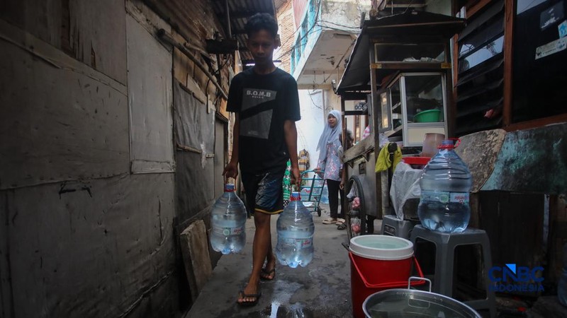 Warga mengambil air bersih dari mobil layanan bantuan air bersih di Jalan H Mawar, Sunter Jaya, Tanjung Priok, Jakarta Utara, Senin (6/7/2026).