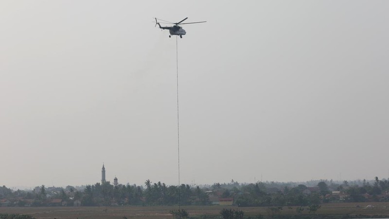Helicopter water bombing mengisi ulang ember (bucket) di Danau Pulo yang berjarak sekitar 700 meter dari lokasi kebakaran TPA Jatiwaringin, Tangerang, Senin (6/7). (Dok BNPB)