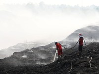 Personil gabungan berjibaku memadamkan api kebakaran TPA Jatiwaringin, Tangerang dengan menggunakan semprotan air pada Senin (6/7). (Dok BNPB)