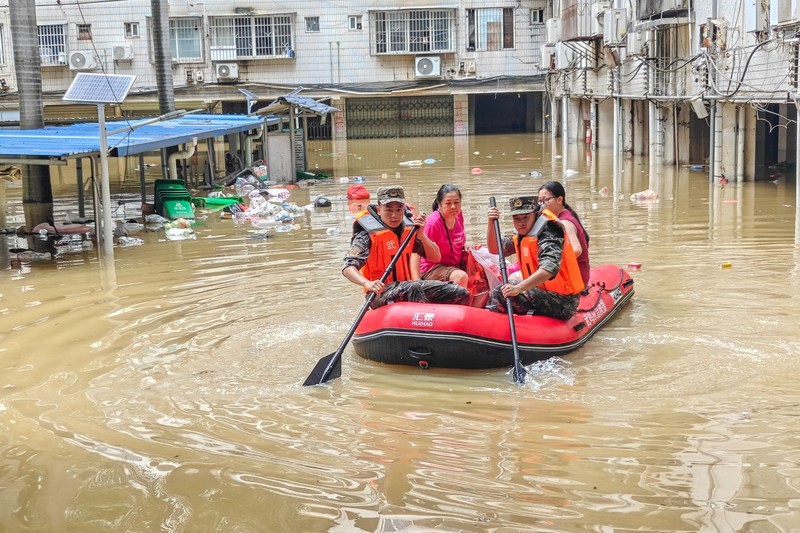 Petugas polisi paramiliter mengevakuasi warga menggunakan perahu karet melalui daerah yang tergenang banjir setelah hujan deras akibat topan Maysak, di Nanning, Daerah Otonomi Guangxi Zhuang, Tiongkok, 6 Juli 2026. (cnsphoto via REUTERS)