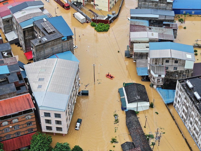Petugas polisi paramiliter mengevakuasi warga menggunakan perahu karet melalui daerah yang tergenang banjir setelah hujan deras akibat topan Maysak, di Nanning, Daerah Otonomi Guangxi Zhuang, Tiongkok, 6 Juli 2026. (cnsphoto via REUTERS)