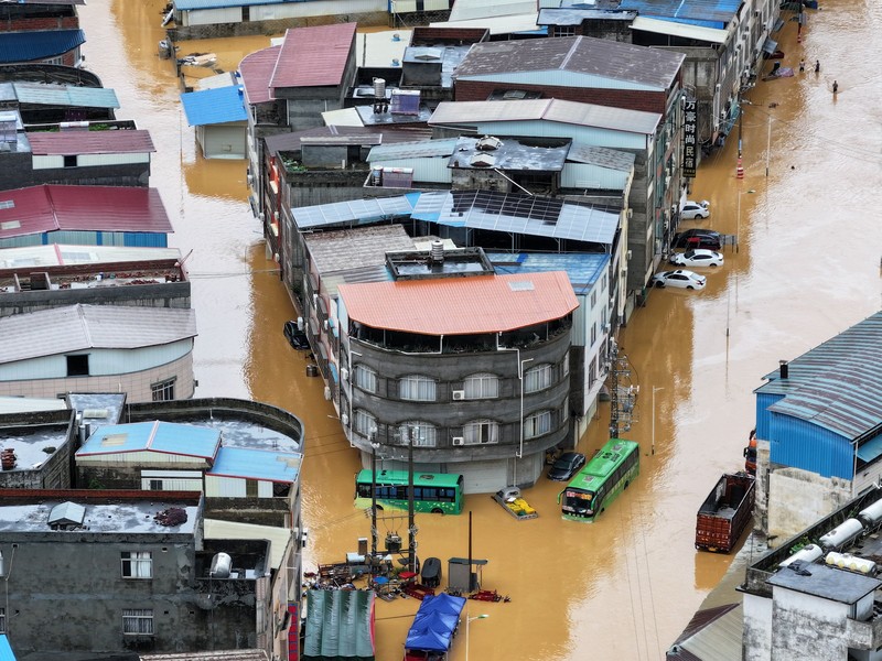 Petugas polisi paramiliter mengevakuasi warga menggunakan perahu karet melalui daerah yang tergenang banjir setelah hujan deras akibat topan Maysak, di Nanning, Daerah Otonomi Guangxi Zhuang, Tiongkok, 6 Juli 2026. (cnsphoto via REUTERS)