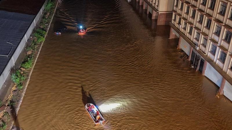 Sebuah tayangan drone menunjukkan para pekerja penyelamat menavigasi perahu melalui air banjir setelah hujan lebat yang dibawa oleh topan Maysak, di Hengzhou, Daerah Otonomi Guangxi Zhuang, Tiongkok, 6 Juli 2026.