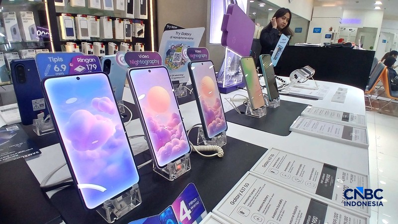 Karyawan toko memperlihatkan jenis smartphone di salah satu mal di Jakarta, Rabu (8/7/2026). (CNBC Indonesia/Tri Susilo)