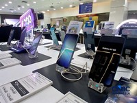 Karyawan toko memperlihatkan jenis smartphone di salah satu mal di Jakarta, Rabu (8/7/2026). (CNBC Indonesia/Tri Susilo)