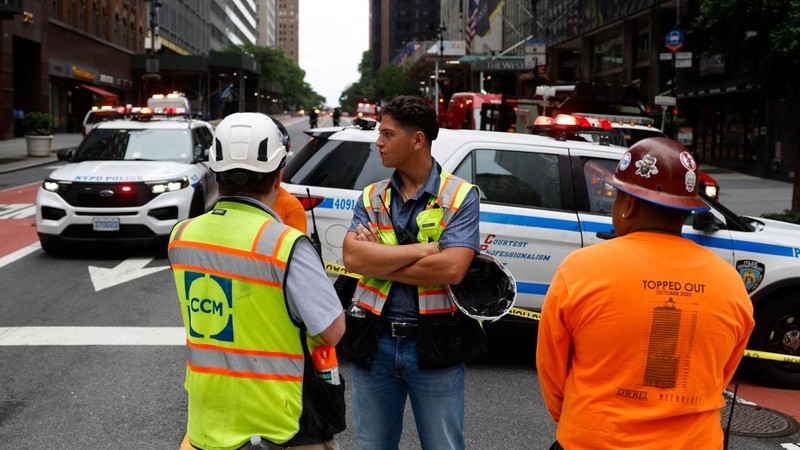 Para pekerja berdiri di dekat sebuah bangunan di Jalan ke-42, yang dilaporkan memiliki masalah struktural, di Kota New York, AS, 7 Juli 2026.