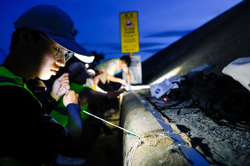 Relawan Wu Ruei-chang, 60 tahun, seorang mekanik mobil, memasang penghalang jalan selama musim kawin kepiting bakau tahunan di Taman Nasional Taijiang di Tainan, Taiwan, 3 Juli 2026. (REUTERS/Ann Wang)