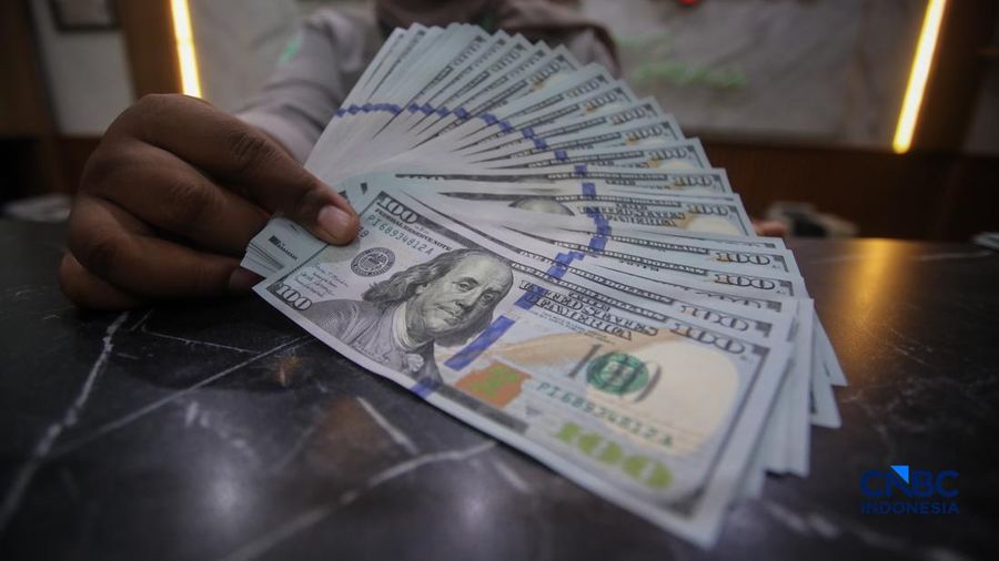Petugas menjunjukkan uang pecahan dolar Amerika Serikat (AS) dan rupiah di Dolar Asia Money Changer, Jakarta, Rabu (8/7/2026). (CNBC Indonesia/Faisal Rahman)