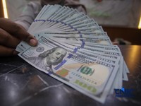 Petugas menjunjukkan uang pecahan dolar Amerika Serikat (AS) dan rupiah di Dolar Asia Money Changer, Jakarta, Rabu (8/7/2026). (CNBC Indonesia/Faisal Rahman)