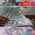 Petugas menjunjukkan uang pecahan dolar Amerika Serikat (AS) dan rupiah diDolar Asia Money Changer, Jakarta, Rabu (8/7/2026).(CNBC Indonesia/Faisal Rahman)