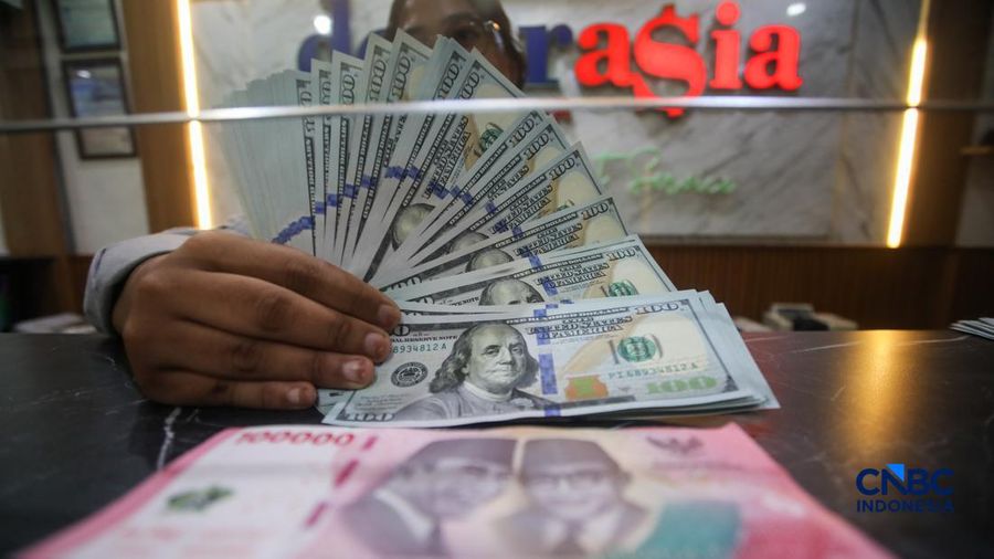 Petugas menjunjukkan uang pecahan dolar Amerika Serikat (AS) dan rupiah diDolar Asia Money Changer, Jakarta, Rabu (8/7/2026).(CNBC Indonesia/Faisal Rahman)