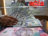 Petugas menjunjukkan uang pecahan dolar Amerika Serikat (AS) dan rupiah diDolar Asia Money Changer, Jakarta, Rabu (8/7/2026).(CNBC Indonesia/Faisal Rahman)