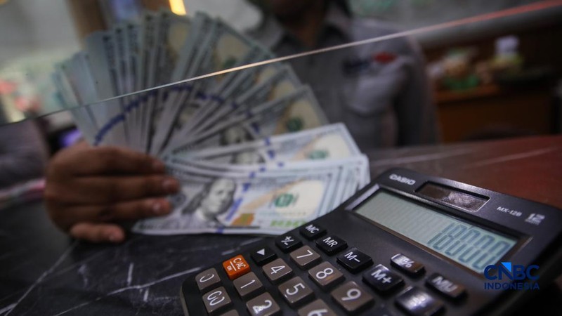 Petugas menjunjukkan uang pecahan dolar Amerika Serikat (AS) dan rupiah di Dolar Asia Money Changer, Jakarta, Rabu (8/7/2026).