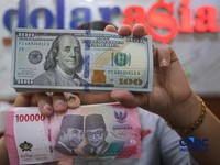 Petugas menjunjukkan uang pecahan dolar Amerika Serikat (AS) dan rupiah di Dolar Asia Money Changer, Jakarta, Rabu (8/7/2026). (CNBC Indonesia/Faisal Rahman)