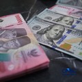 Petugas menjunjukkan uang pecahan dolar Amerika Serikat (AS) dan rupiah di Dolar Asia Money Changer, Jakarta, Rabu (8/7/2026). (CNBC Indonesia/Faisal Rahman)