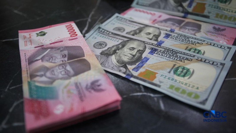 Petugas menjunjukkan uang pecahan dolar Amerika Serikat (AS) dan rupiah di Dolar Asia Money Changer, Jakarta, Rabu (8/7/2026).