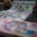 Petugas menjunjukkan uang pecahan dolar Amerika Serikat (AS) dan rupiah di Dolar Asia Money Changer, Jakarta, Rabu (8/7/2026). (CNBC Indonesia/Faisal Rahman)