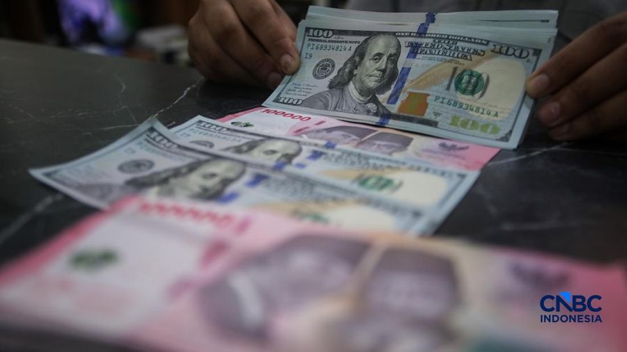 Petugas menjunjukkan uang pecahan dolar Amerika Serikat (AS) dan rupiah di Dolar Asia Money Changer, Jakarta, Rabu (8/7/2026). (CNBC Indonesia/Faisal Rahman)