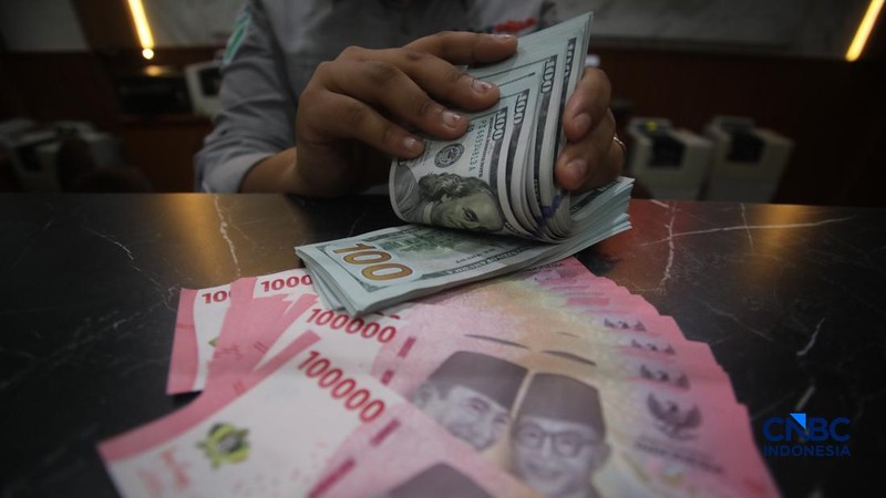 Petugas menjunjukkan uang pecahan dolar Amerika Serikat (AS) dan rupiah di Dolar Asia Money Changer, Jakarta, Rabu (8/7/2026).