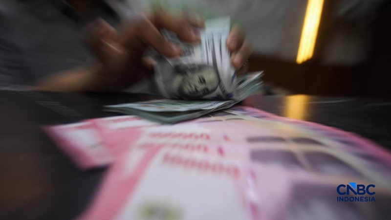 Petugas menjunjukkan uang pecahan dolar Amerika Serikat (AS) dan rupiah di Dolar Asia Money Changer, Jakarta, Rabu (8/7/2026).