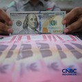 Petugas menjunjukkan uang pecahan dolar Amerika Serikat (AS) dan rupiah di Dolar Asia Money Changer, Jakarta, Rabu (8/7/2026). (CNBC Indonesia/Faisal Rahman)