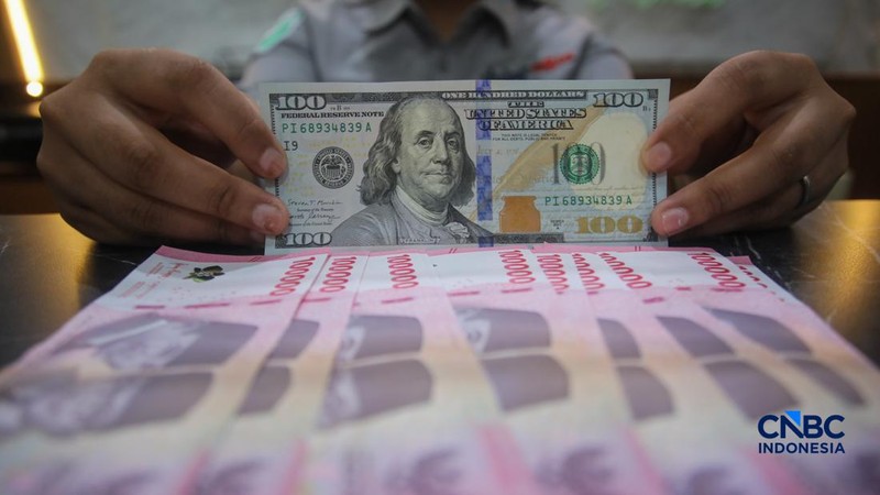 Petugas menjunjukkan uang pecahan dolar Amerika Serikat (AS) dan rupiah di Dolar Asia Money Changer, Jakarta, Rabu (8/7/2026).