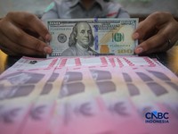 Petugas menjunjukkan uang pecahan dolar Amerika Serikat (AS) dan rupiah di Dolar Asia Money Changer, Jakarta, Rabu (8/7/2026). (CNBC Indonesia/Faisal Rahman)