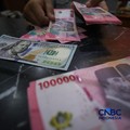 Petugas menjunjukkan uang pecahan dolar Amerika Serikat (AS) dan rupiah diDolar Asia Money Changer, Jakarta, Rabu (8/7/2026).(CNBC Indonesia/Faisal Rahman)