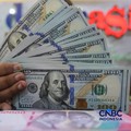 Petugas menjunjukkan uang pecahan dolar Amerika Serikat (AS) dan rupiah di Dolar Asia Money Changer, Jakarta, Rabu (8/7/2026). (CNBC Indonesia/Faisal Rahman)