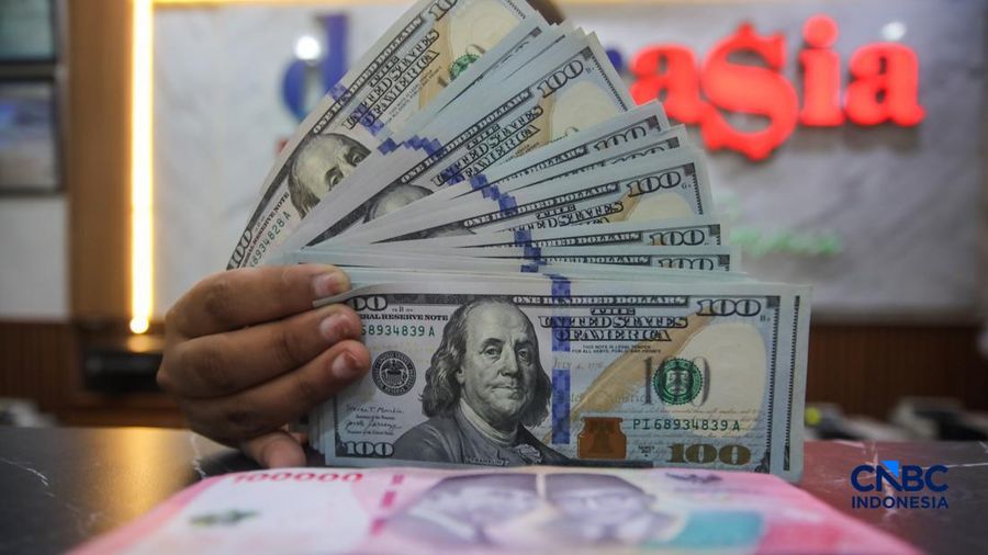 Petugas menjunjukkan uang pecahan dolar Amerika Serikat (AS) dan rupiah di Dolar Asia Money Changer, Jakarta, Rabu (8/7/2026). (CNBC Indonesia/Faisal Rahman)