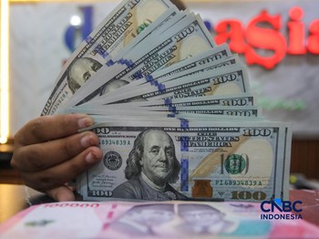 Petugas menjunjukkan uang pecahan dolar Amerika Serikat (AS) dan rupiah di Dolar Asia Money Changer, Jakarta, Rabu (8/7/2026). (CNBC Indonesia/Faisal Rahman)