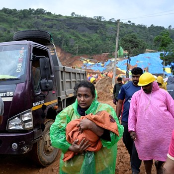 Seorang wanita menggendong bayi saat ia berpindah ke tempat yang lebih aman setelah tanah longsor di dekat Jembatan Meenakshi, dekat lokasi proyek terowongan di distrik Wayanad, di negara bagian Kerala selatan, India, 7 Juli 2026. (REUTERS/CK Thansee