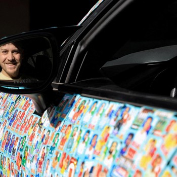 Chilean soccer fan and content creator Ariel Osses smiles while sitting in his car, which is covered with FIFA World Cup 2026 Panini stickers, fulfilling an updated version of his childhood dream of having a World Cup Panini album, in Santiago, Chile
