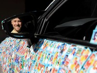 Chilean soccer fan and content creator Ariel Osses smiles while sitting in his car, which is covered with FIFA World Cup 2026 Panini stickers, fulfilling an updated version of his childhood dream of having a World Cup Panini album, in Santiago, Chile