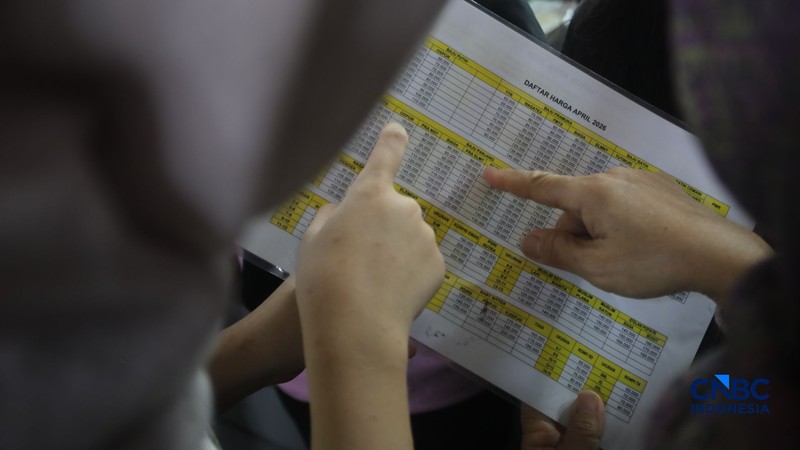 Orang tua mencocokkan seragam sekolah ke anaknya pada toko penyedia seragam sekolah di Pasar Tanah Abang, Jakarta, Kamis (9/7/2026). (CNBC Indonesia/Faisal Rahman)