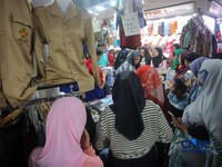 Orang tua mencocokkan seragam sekolah ke anaknya pada toko penyedia seragam sekolah di Pasar Tanah Abang, Jakarta, Kamis (9/7/2026).(CNBC Indonesia/Faisal Rahman)