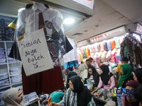 Orang tua mencocokkan seragam sekolah ke anaknya pada toko penyedia seragam sekolah di Pasar Tanah Abang, Jakarta, Kamis (9/7/2026). (CNBC Indonesia/Faisal Rahman)