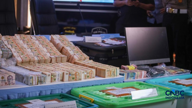 Barang bukti emas batangan hingga dolar AS ditampilkan jelang konferensi pers perkembangan penyidikan kasus dugaan tindak pidana korupsi, gratifikasi, dan/atau tindak pidana pencucian uang di Gedung Promoter Polda Metro Jaya, Jakarta, Jumat (10/7/2026). (CNB Indonesia/Faisal Rahman)