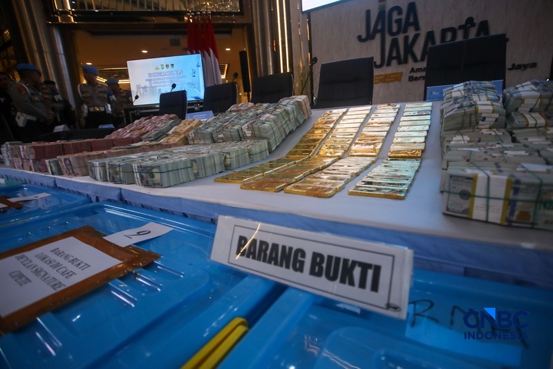 Barang bukti emas batangan hingga dolar AS ditampilkan saat konferensi pers perkembangan penyidikan kasus dugaan tindak pidana korupsi, gratifikasi, dan/atau tindak pidana pencucian uang di Gedung Promoter Polda Metro Jaya, Jakarta, Jumat (10/7/2026).  (CNBC Indonesia/Faisal Rahman)