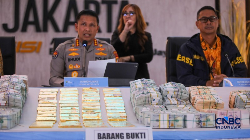 Barang bukti emas batangan hingga dolar AS ditampilkan saat konferensi pers perkembangan penyidikan kasus dugaan tindak pidana korupsi, gratifikasi, dan/atau tindak pidana pencucian uang di Gedung Promoter Polda Metro Jaya, Jakarta, Jumat (10/7/2026).  (CNBC Indonesia/Faisal Rahman)