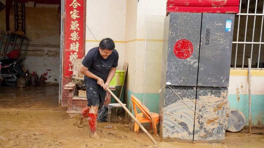 Seorang warga membersihkan lumpur dari rumah yang terendam banjir setelah hujan lebat akibat topan Maysak, dekat Waduk Liulan di Hengzhou, Daerah Otonomi Guangxi Zhuang, Tiongkok, 8 Juli 2026.
