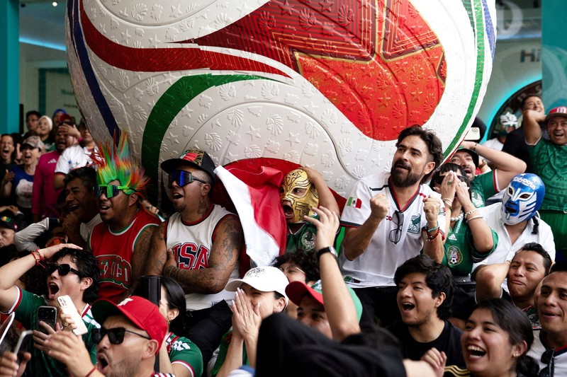 Soccer Football - FIFA World Cup 2026 - Mexico v South Africa -  Fans gather in Mexico City - Zocalo, Mexico City, Mexico - June 11, 2026 - A giant FIFA World Cup 2026 ball behind Mexico fans reacting as they watch the match REUTERS/Marian Carrasquero     TPX IMAGES OF THE DAY          SEARCH