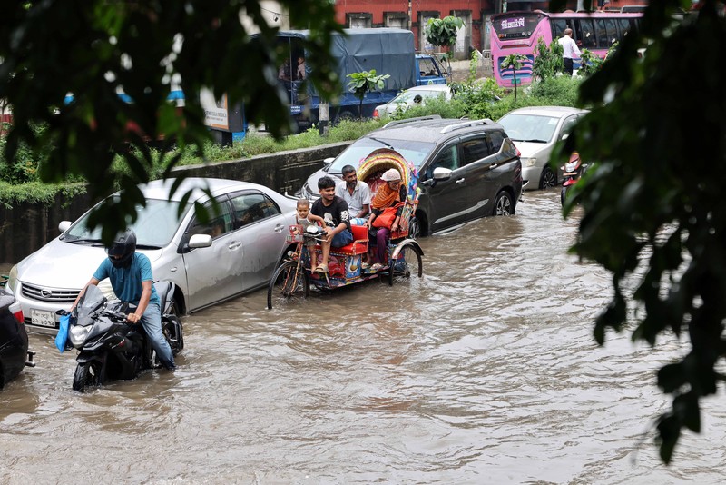 Kendaraan melintas di jalan yang tergenang banjir setelah hujan deras di Dhaka, Bangladesh, 12 Juli 2026. (REUTERS/Mohammad Ponir Hossain)