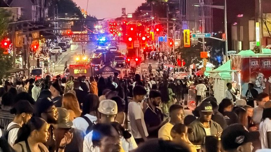 Orang-orang berkumpul saat petugas darurat memberikan pertolongan di lokasi kejadian setelah penembakan mematikan, di sebuah festival jalanan bertema salsa di Toronto, Ontario, Kanada, 11 Juli 2026. (REUTERS/Cole Burston)