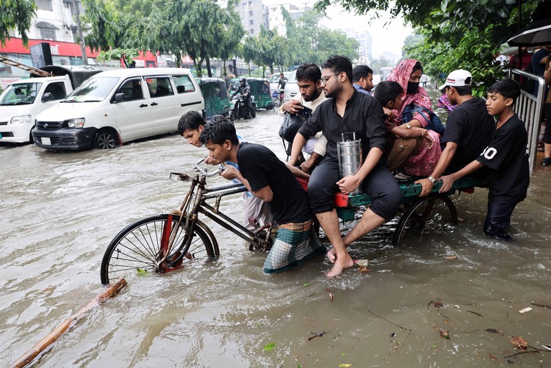 Kendaraan melintas di jalan yang tergenang banjir setelah hujan deras di Dhaka, Bangladesh, 12 Juli 2026. (REUTERS/Mohammad Ponir Hossain)