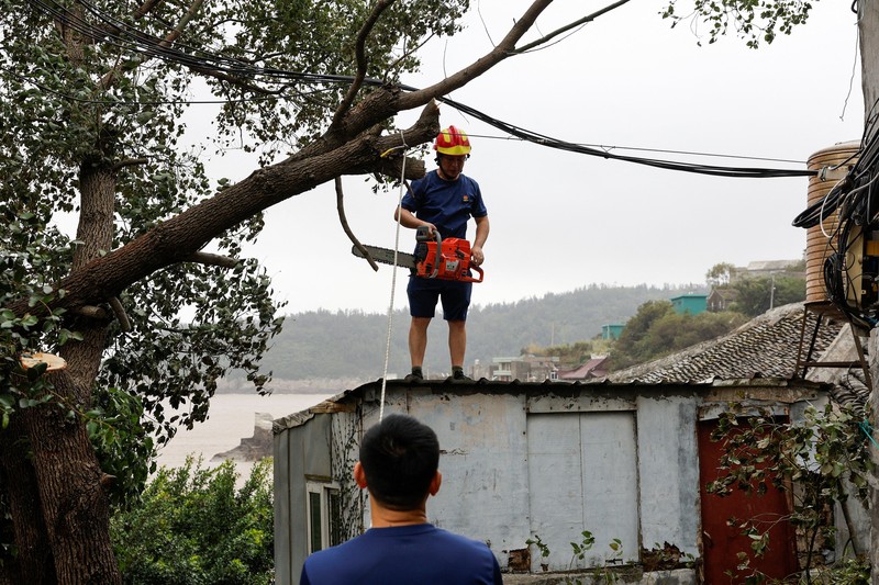 Warga memandang ke arah laut setelah Topan Bavi melanda daerah tersebut di desa pesisir Diaocaocun, Taizhou, provinsi Zhejiang, China, 12 Juli 2026. (REUTERS/Go Nakamura)