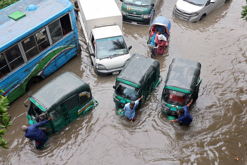 Kendaraan melintas di jalan yang tergenang banjir setelah hujan deras di Dhaka, Bangladesh, 12 Juli 2026. (REUTERS/Mohammad Ponir Hossain)