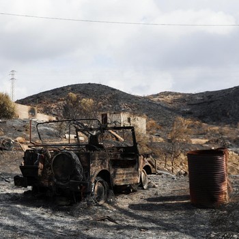 Sebuah kendaraan yang terbakar di area yang terbakar setelah kebakaran hutan mematikan di Almocaizar, Almeria, Spanyol, 12 Juli 2026. (REUTERS/Loyola Perez de Villegas Muniz)