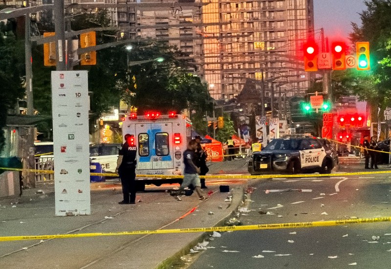 Orang-orang berkumpul saat petugas darurat memberikan pertolongan di lokasi kejadian setelah penembakan mematikan, di sebuah festival jalanan bertema salsa di Toronto, Ontario, Kanada, 11 Juli 2026. (REUTERS/Cole Burston)